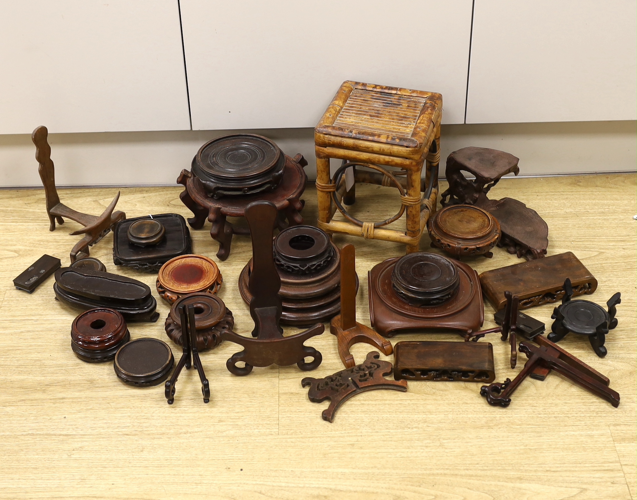 A collection of Chinese carved wooden stands and a small bamboo stand